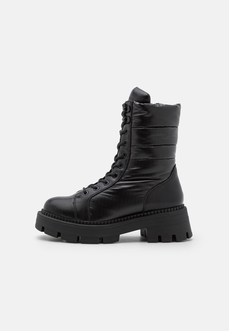 Botte de combat noire à lacets avec tige rembourrée, bout rond, semelle épaisse et finition texturée. Présente des coutures contrastées et une semelle en caoutchouc épaisse.