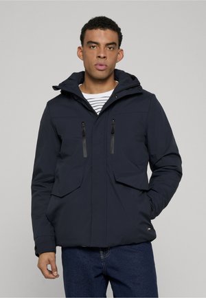 Mørkeblå jakke med hætte, der har to lynlåslommer på brystet og to store frontlommer, fremstillet af glat og let materiale.