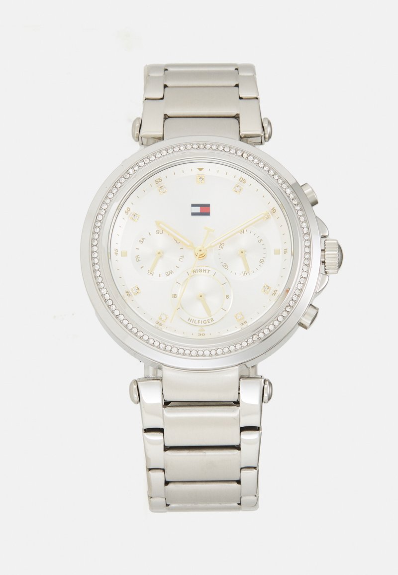 Montre en acier inoxydable argenté avec un cadran rond blanc, des accents dorés, une lunette en cristal et des sous-cadrans chronographes multifacettes.