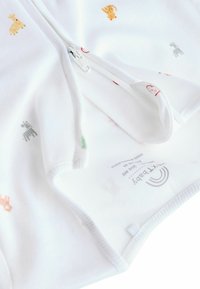 Witte ritsbodysuit van zacht materiaal, met kleurrijke dierenprints, en een soepele rits aan de voorkant voor gemakkelijk aankleden.