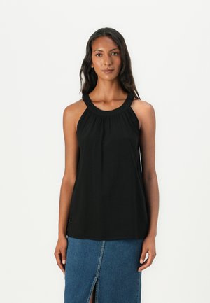 Top noir sans manches avec un décolleté arrondi et des détails froncés. Le tissu est lisse, porté sur une jupe en denim avec une fente à l'avant.