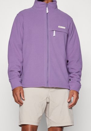 Paarse fleecejas met volledige ritssluiting, hoge kraag en een borstzak. Gladde textuur, lange mouwen en witte ritssluitingdetails.