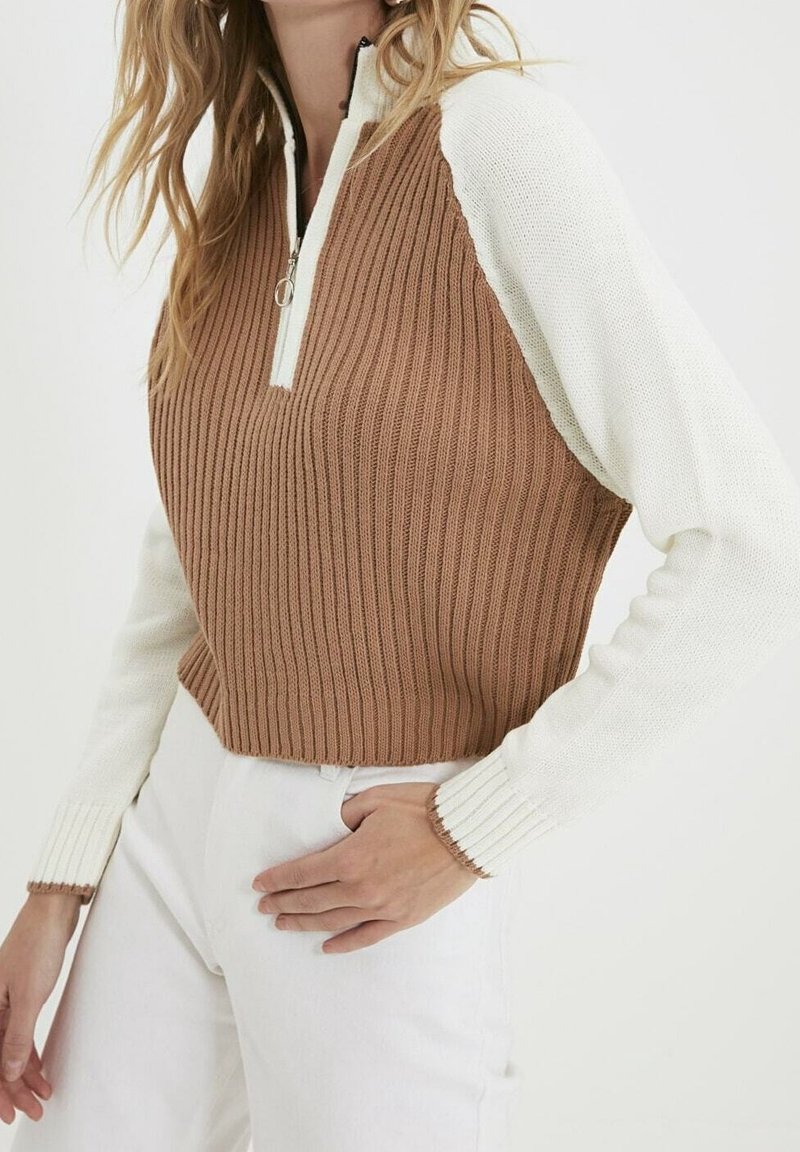 Bruine en witte geribde gebreide pullover met een halflange ritskraag. Kenmerkt lange mouwen en een cropped silhouet. Accenten zijn contrasterende cuffs.