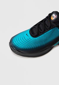 Sininen ja musta Nike Air Max -lenkkari, jossa on kuvioitu päällinen, mustat nauhat ja "Air Max" -logo kielessä valkoista taustaa vasten.