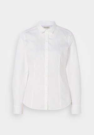 Chemise blanche à boutons fabriquée en coton lisse, avec un col classique, des manches longues et un logo subtil sur la poitrine. Présente une fermeture à boutons sur le devant.