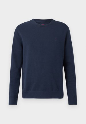 Marineblå crewneck sweater med lange ærmer, ribbet manchetter og kant samt lille rød, hvid og blå logo på venstre bryst.