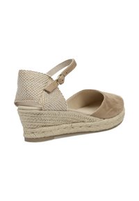 Sandalia de cuña con parte superior de ante beige, parte trasera texturizada y tejida, correa ajustable en el tobillo y tacón envuelto en yute para mayor altura.