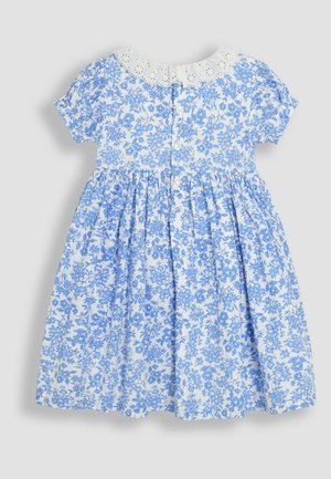 Niebieska kwiecista sukienka bawełniana z krótkimi rękawami, białą koronkową kołnierzykiem i rozkloszowanym dołem. Posiada zapięcie na guziki z tyłu.