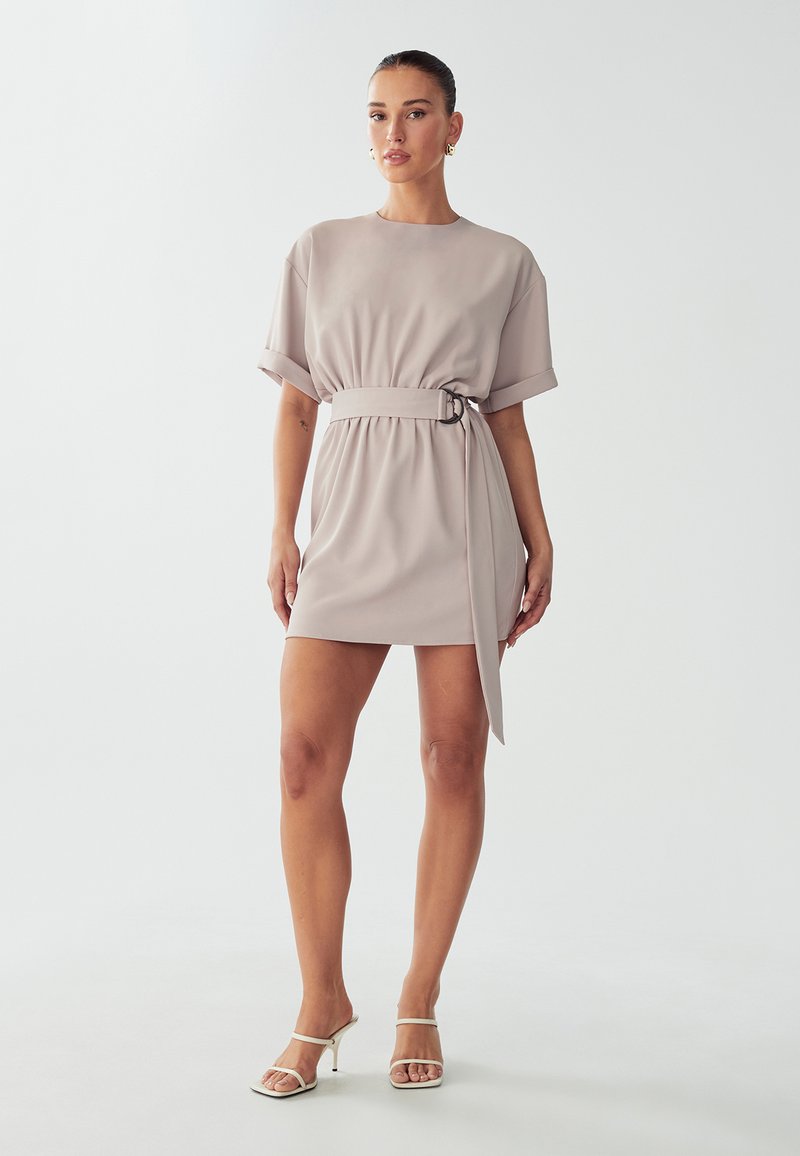 Kortekorte, lichtbeige jurk met een ceintuur in de taille en een gedrapeerde rok. Gladde stof met een rechte zoom en opgerolde mouwen.