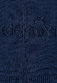 Tessuto lavorato a maglia blu scuro con delicate ricami a rilievo di note musicali nello stesso filo.