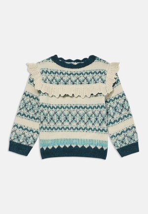 Knit sweater with a cream base, teal, and blue geometric patterns. Features a ruffled collar and scalloped hem. Long sleeves. Soft texture.