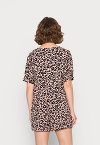 Macacão de estampa de leopardo em rosa e preto. Apresenta mangas curtas, um corte solto e decote em forma de U, feito de um tecido leve.