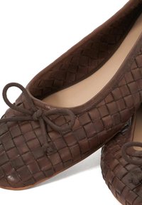 Brown woven leather ballet flats with a round toe, featuring a tied bow detail on the front and a smooth inner lining.