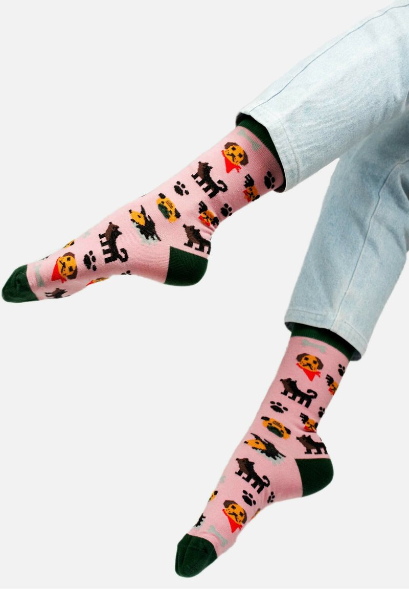 Różowe skarpetki z ilustracjami kotów i psów, zielonymi akcentami na mankiecie oraz wzorami w kształcie śladów łap i produktów spożywczych. Wykonane z bawełny.