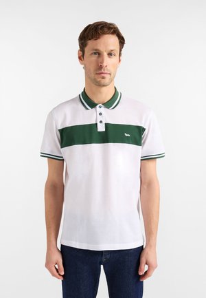 Polo bianca con una striscia orizzontale verde, chiusura a tre bottoni e colletto a righe a contrasto. Piccolo logo sul petto.