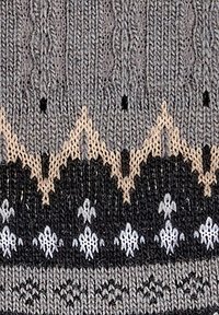 Knit fabric with gray, black, and beige colors. Features zigzag and floral patterns. Textured with a cable-knit design.