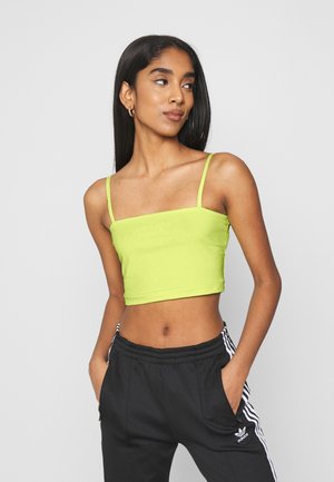 Limegrønn, kort tanktopp med tynne stropper og rett utringning. Laget av elastisk stoff med brodert logo-detalj på forsiden.
