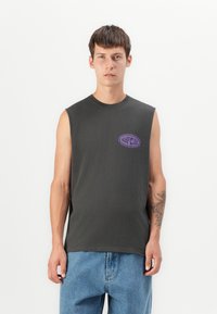 Sötét szürke, ujjatlan póló, kerek nyakkivágással és lila "Rip Curl" logóval a mellrészen, puha pamut anyagból készült.