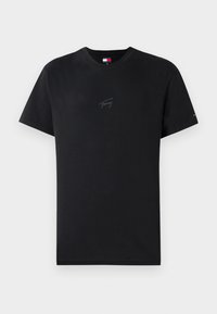 Camiseta negra de manga corta con cuello redondo, con un discreto texto "Tommy" en el pecho y un pequeño logo de Tommy Jeans en la manga izquierda.