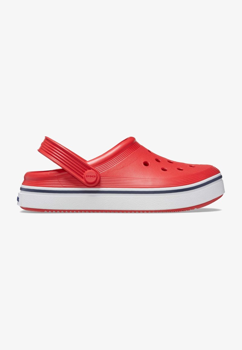 Sabot rouge à enfiler avec des trous de ventilation, une semelle blanche avec une bande marine et une bride réglable au talon, vu de profil.
