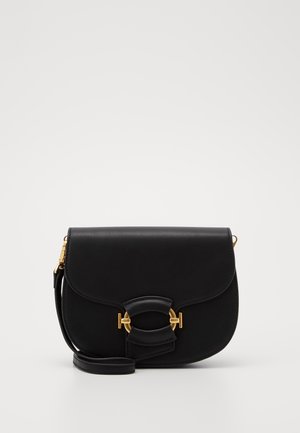 Sac en cuir noir à bandoulière avec un rabat, doté d'un fermoir en métal doré et d'un accent incurvé. Texture lisse avec un design minimaliste.