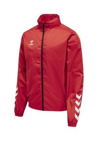 Rote leichte Sportjacke mit Frontreißverschluss, hohem Kragen, weißem hummel-Logo auf der Brust und weißen Chevrons an den Ärmeln.