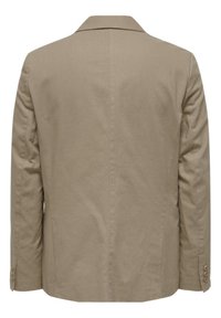 Blazer beige con una textura suave, solapa muesca y tres botones en cada puño. Presenta un diseño limpio y minimalista.