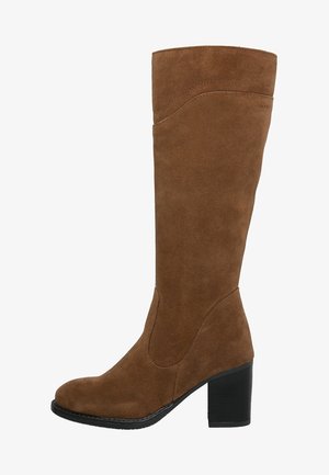 Botte haute en suède marron avec un bout rond, une texture lisse et un large talon noir. Comprend un détail de couture courbé sur la tige.