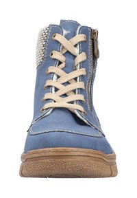 Niebieski skórzany botek z beżowymi sznurowadłami i teksturowaną gumową podeszwą. Posiada boczny zamek błyskawiczny oraz dekoracyjny panel z tkaniny przy cholewce.