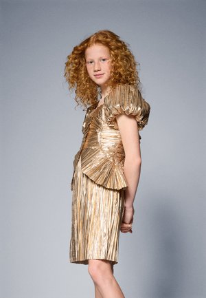 Gold plissiertes Kleid mit Puffärmeln, figurbetontem Oberteil und ausgestelltem Peplum, mit einer glatten, glänzenden Textur, die das Licht reflektiert.