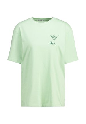 Camiseta de algodón verde claro con mangas cortas. Presenta un gráfico de una copa de Martini en la parte izquierda del pecho. Cuello de barco clásico.