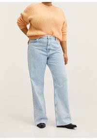 Lichtblauwe wijde jeans met een hoge taille, gedragen met een textuurvolle perzikkleurige trui met een geribbelde structuur en lange mouwen.