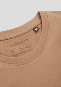 Brązowa bawełniana koszulka z okrągłym dekoltem. Posiada metkę z ikonami pielęgnacyjnymi oraz brandingiem "LANCERTO" w pobliżu kołnierza. Widoczna metka z rozmiarem.