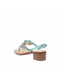 Sandal in blu acqua con tacco basso in legno, finemente dettagliato con gemme trasparenti e turchesi su una tomaia in tessuto lavorato.