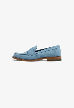Lyseblå loafers lavet af denimstof med et syet design, rund tå og en brun lædersål med en lille hæl.