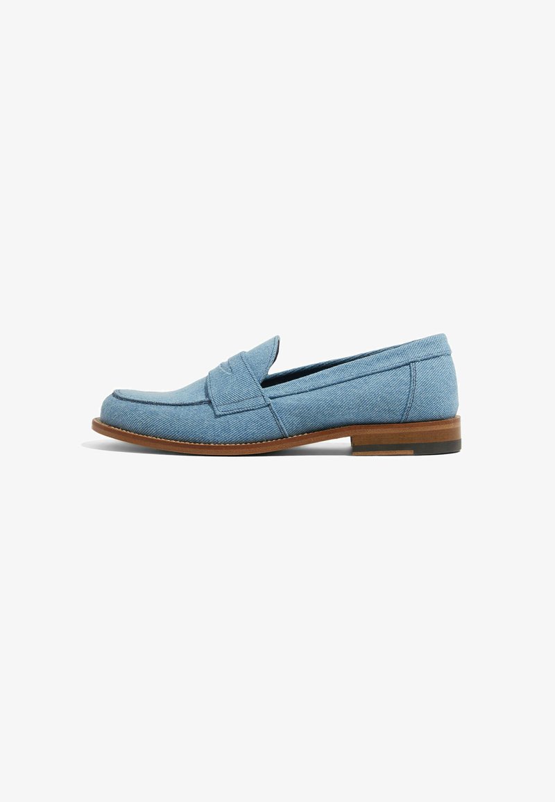 Lyseblå loafers lavet af denimstof med et syet design, rund tå og en brun lædersål med en lille hæl.