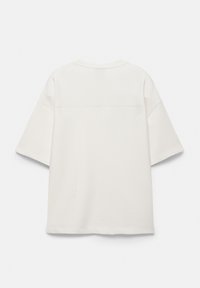 T-shirt blanc uni à manches courtes, épaules tombantes et col rond, vu de dos sur un fond clair.