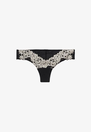 Tanga de encaje negro con bordado floral en crema a lo largo de la cintura, con tejido de malla transparente y parte frontal sólida.
