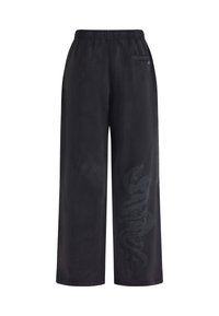 Pantaloni neri a gamba larga realizzati in tessuto morbido, con vita elastica e un sottile motivo a serpente lungo la gamba sinistra.