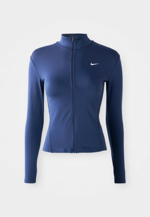 Chaqueta deportiva ajustada de color azul marino con cremallera para mujer, con mangas largas y logo de Nike en blanco en el pecho.