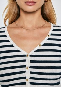 Langarm gestreifter Cardigan in Weiß und Marineblau, mit einem V-Ausschnitt und Holzknöpfen vorne, aus einem gerippten Stoff gefertigt.