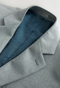 Gray textured suit jacket with a teal patterned lining. Features a notched collar and a single decorative stitch on the lapel.