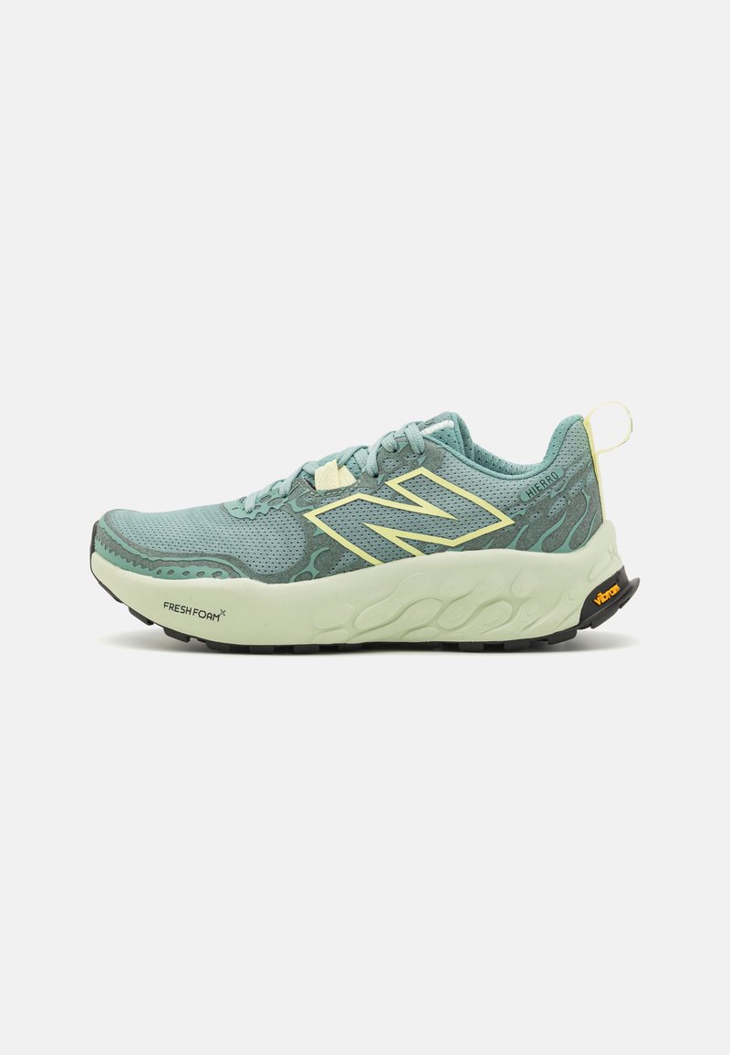 Light green running shoe with a textured upper, featuring a yellow accent on the logo, lace, and pull tab, and a cushioned sole design.