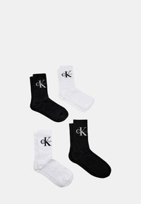 Calzini in cotone bianco e nero con il logo 'CK'. I calzini hanno una trama a coste e sono di lunghezza media fino al polpaccio.