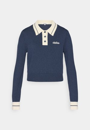 Jersey de polo de punto en color navy con cuello beige en contraste y tapeta de tres botones. Presenta puños y dobladillo acanalados con acentos a rayas.