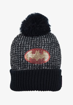 Gebreide zwarte en grijze beanie met een pompon bovenop, voorzien van een gouden en rode Batman-logo patch op een ovale achtergrond. Geverfde ribbelmanchette.