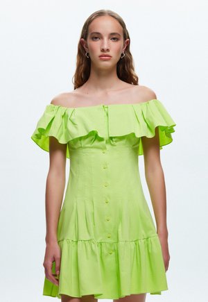 Vestido verde lima de un solo hombro con mangas con volantes, cierre de botones y diseño de falda escalonada. Fabricado con tejido ligero.
