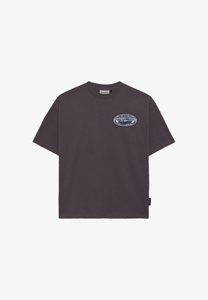 Mørkegrå T-shirt med korte ærmer, rund hals og lille ovalt logoemblem på venstre bryst med teksten "Prohibited Racing Club".