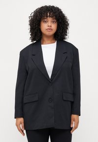 Svart blazer med en skreddersydd design, som har to frontlommer, notched krager og knappelukking. Glatt stofftekstur.