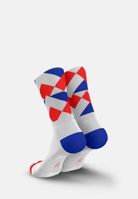 Socks with a geometric pattern in red, blue, and white. Made of fabric with a smooth texture. Rounded toe and ribbed cuff design.
